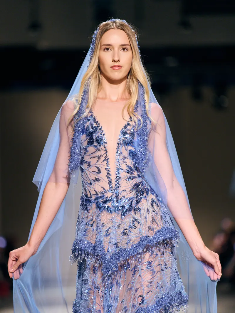 Lisa on the AAVVA runway in a sheer blue embroidered gown with a flowing veil