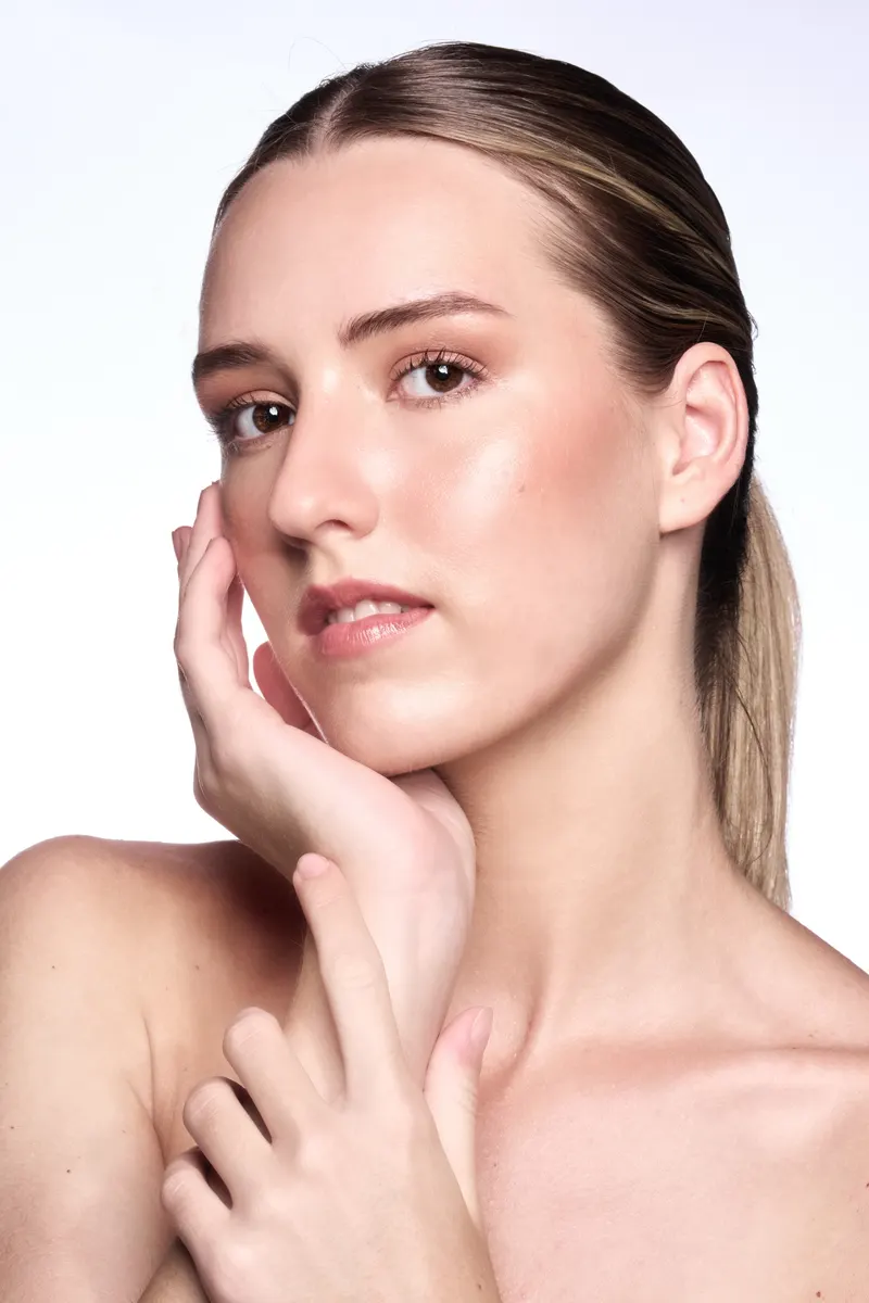 Beauty portrait of Lisa with fresh skin and hand resting on her cheek