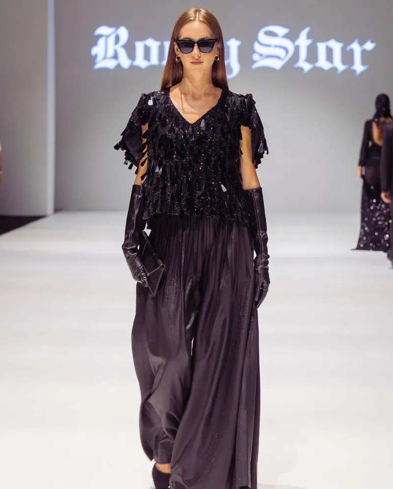 Lisa on the Rocky Star runway in a black fringed top and wide trousers