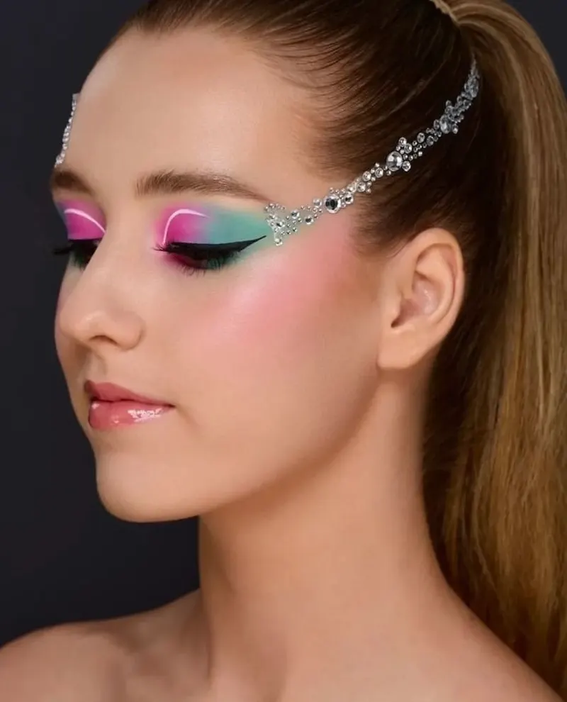 Close up of Lisa with pink and turquoise eye makeup and a jewelled headpiece