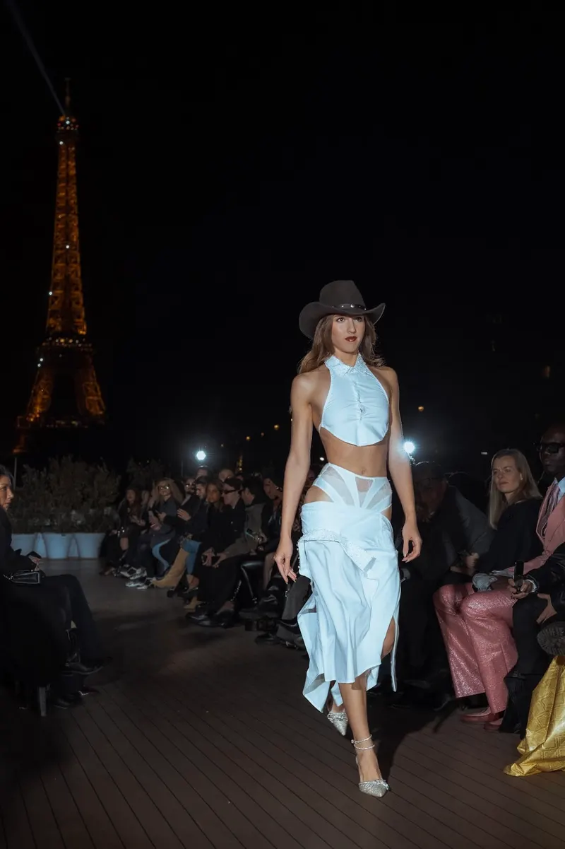 Lisa on an evening runway in Paris in a pale blue halter look and hat