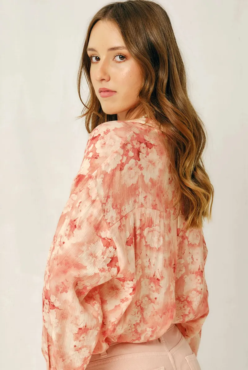 Lisa looking over her shoulder in a pink floral blouse