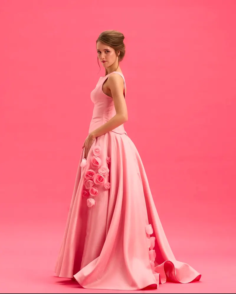 Lisa in a pink satin gown with rose appliques on a pink backdrop
