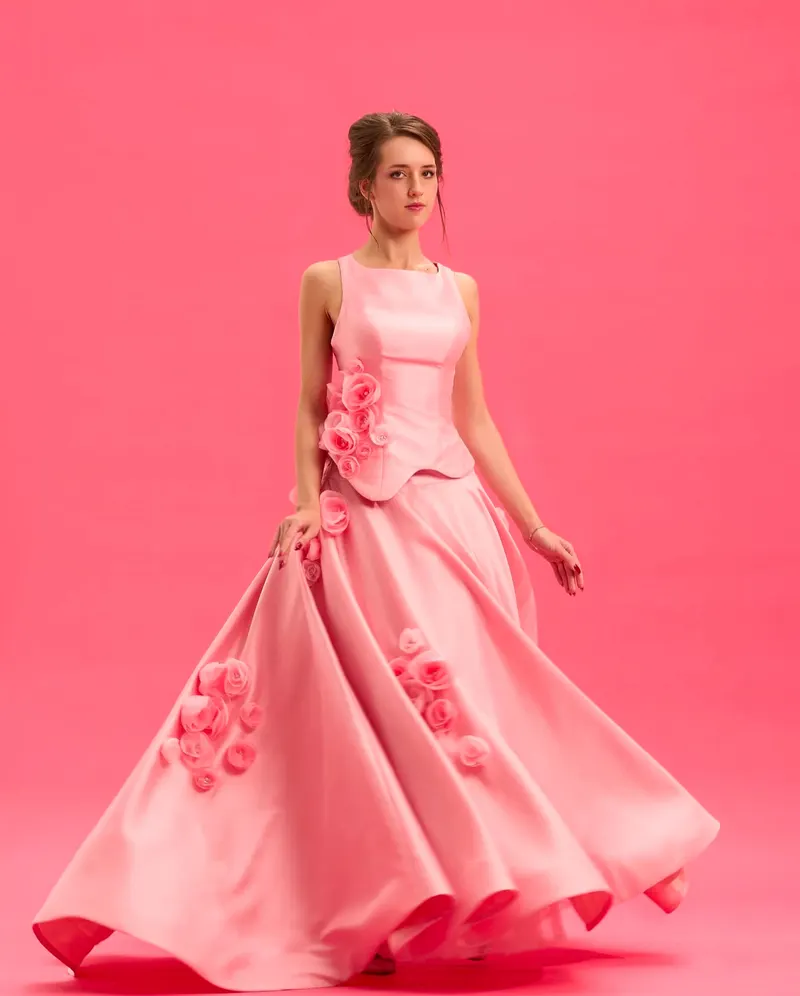 Lisa twirling in a pink satin ball gown with rose appliques